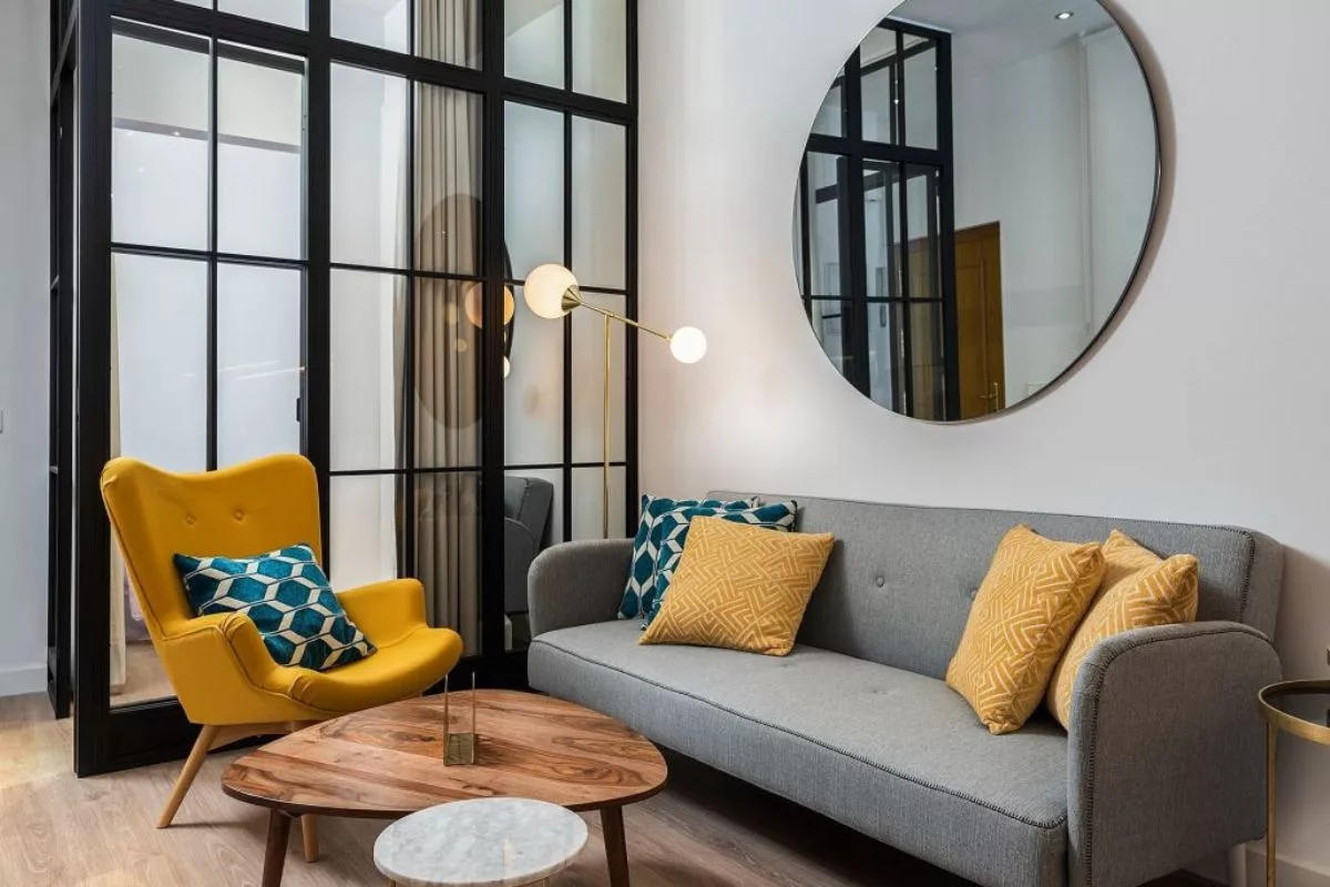 Espelhos atrás do sofá ajudam a dar sofisticação à decoração