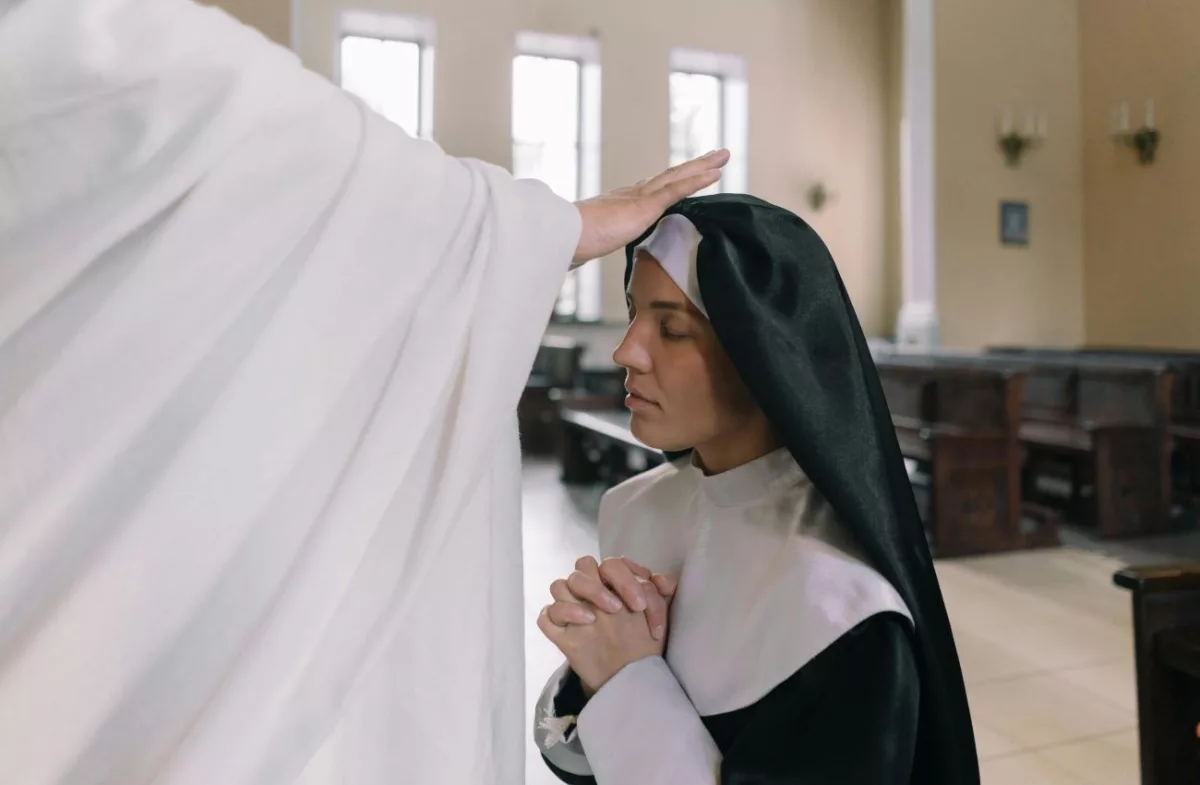 Padre abençoa freira durante ritual litúrgico